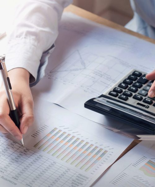 finance and accounting concept. business woman working on desk using calculator to calculate in office